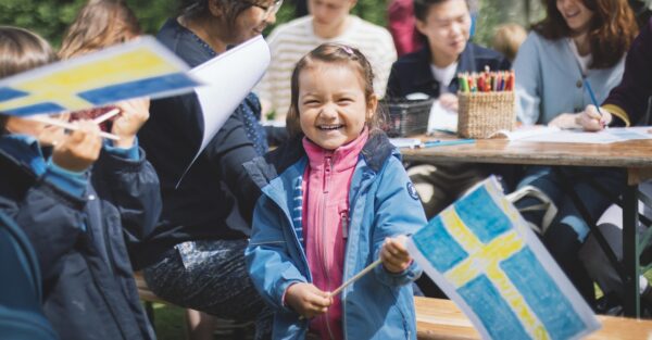 En liten flicka har tillverkat en egen svensk flagga under nationaldagen på Skansen.