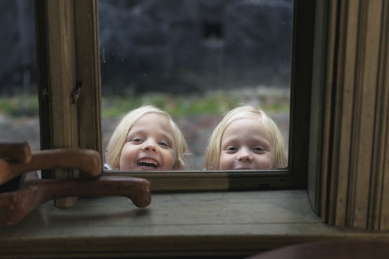 Girls curiously peek through the window.